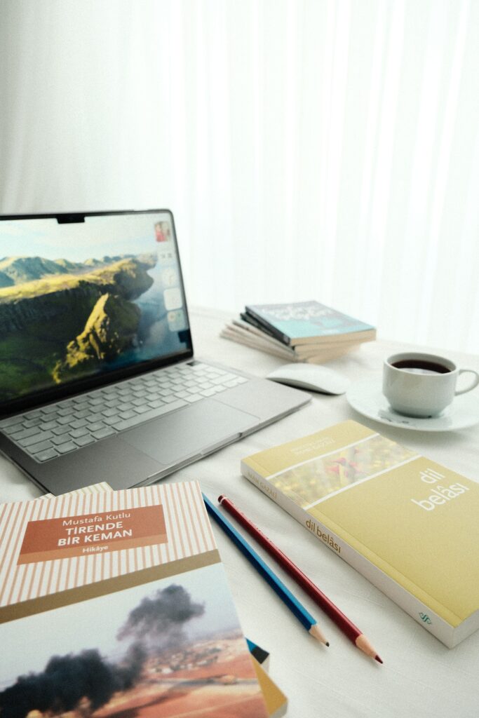 Inviting workspace with laptop, books, and coffee, perfect for productivity.
